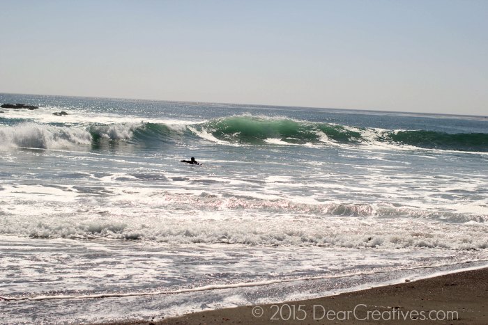 surfer swimming out to waves