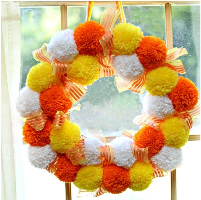 pom pom candy corn wreath diy via littlemisscelebration