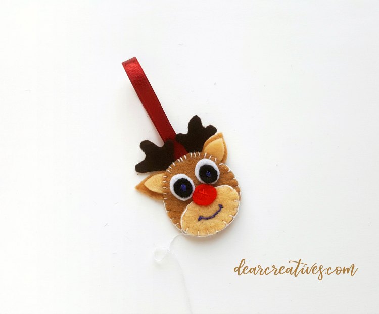 felt reindeer head with ribbon attached to hang ornament on holiday tree Full tutorial at DearCreatives.com