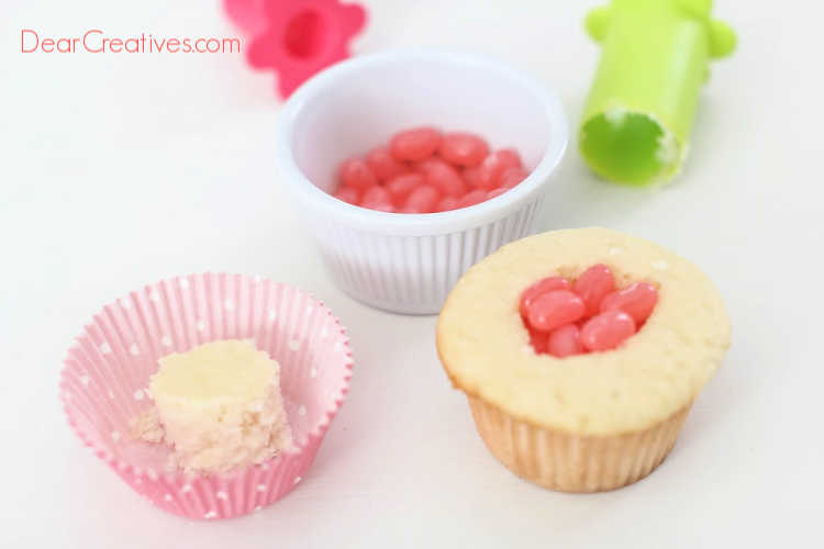 Adding jelly beans into the hole of the cupcake that was cored out. Recipe and how to at DearCreatives.com