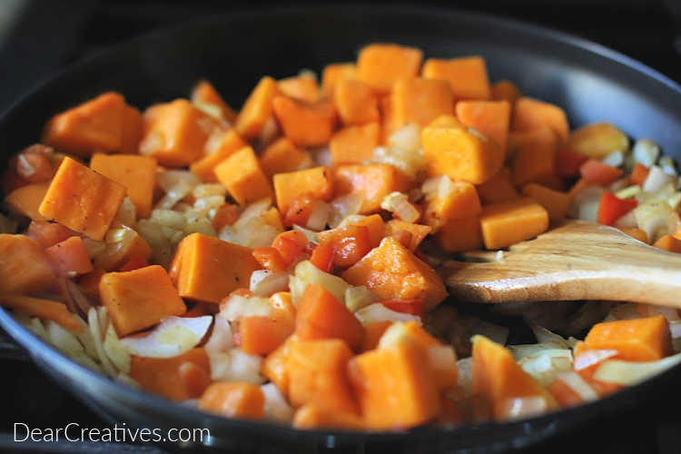 Adding butternut squash to the onions, garlic, carrots and red bell peppers for chili with black beans and squash. DearCreatives.com