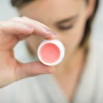 Holding-round-white-and-pink-lip-balm- DIY Lip Balm - DearCreatives.com