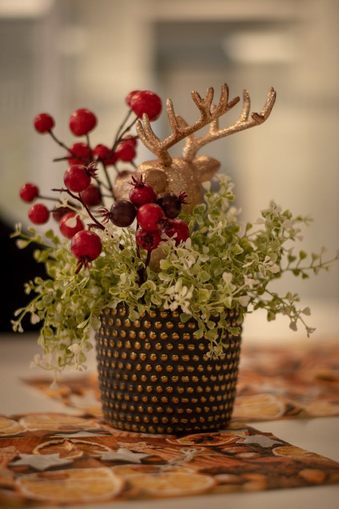 Close-up of festive plant arrangement with berries and reindeer ornament.