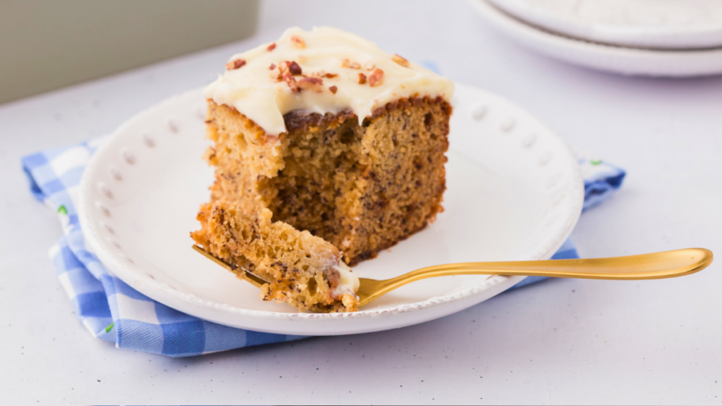 Banana Cake with cream cheese frosting. This is an easy recipe made in a square baking pan, perfect for snacking or serving as a dessert. Click over to print the recipe! DearCreatives.com 