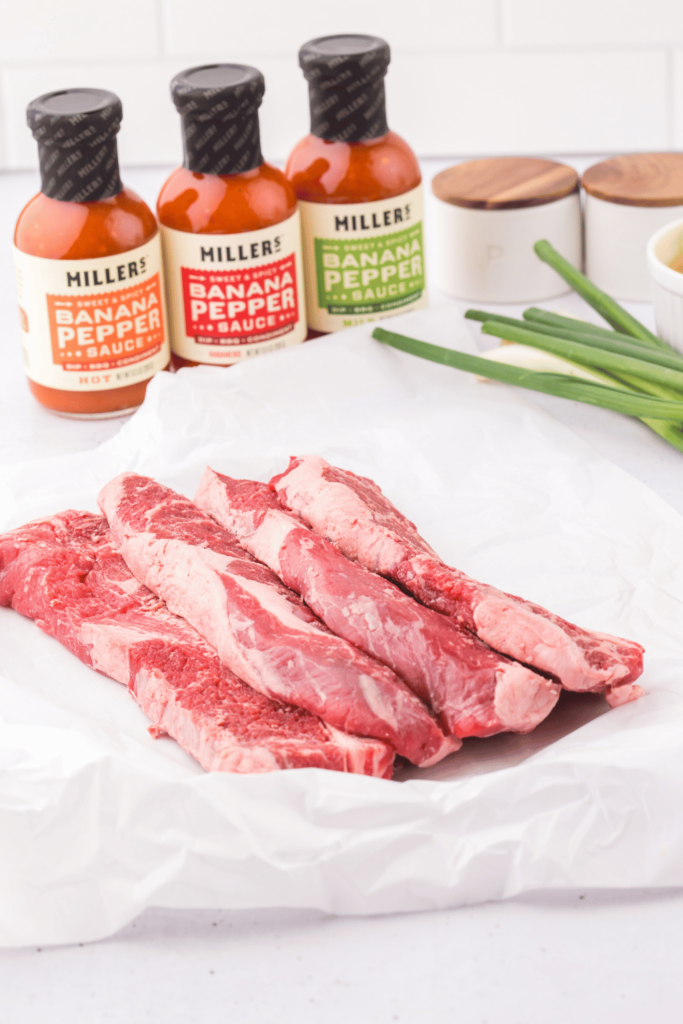 Ingredients for beef short ribs - beef short ribs flanken style, Miller's Banana Pepper Sauces in mild, habanero, and hot, green onions, pineapple chunks... Get the easy 5 ingredient recipe at DearCreatives.com 